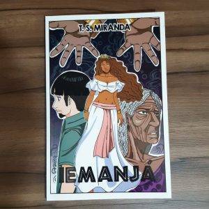 Mangá "Iemanjá" de T. S. Miranda sobre uma mesa de madeira.